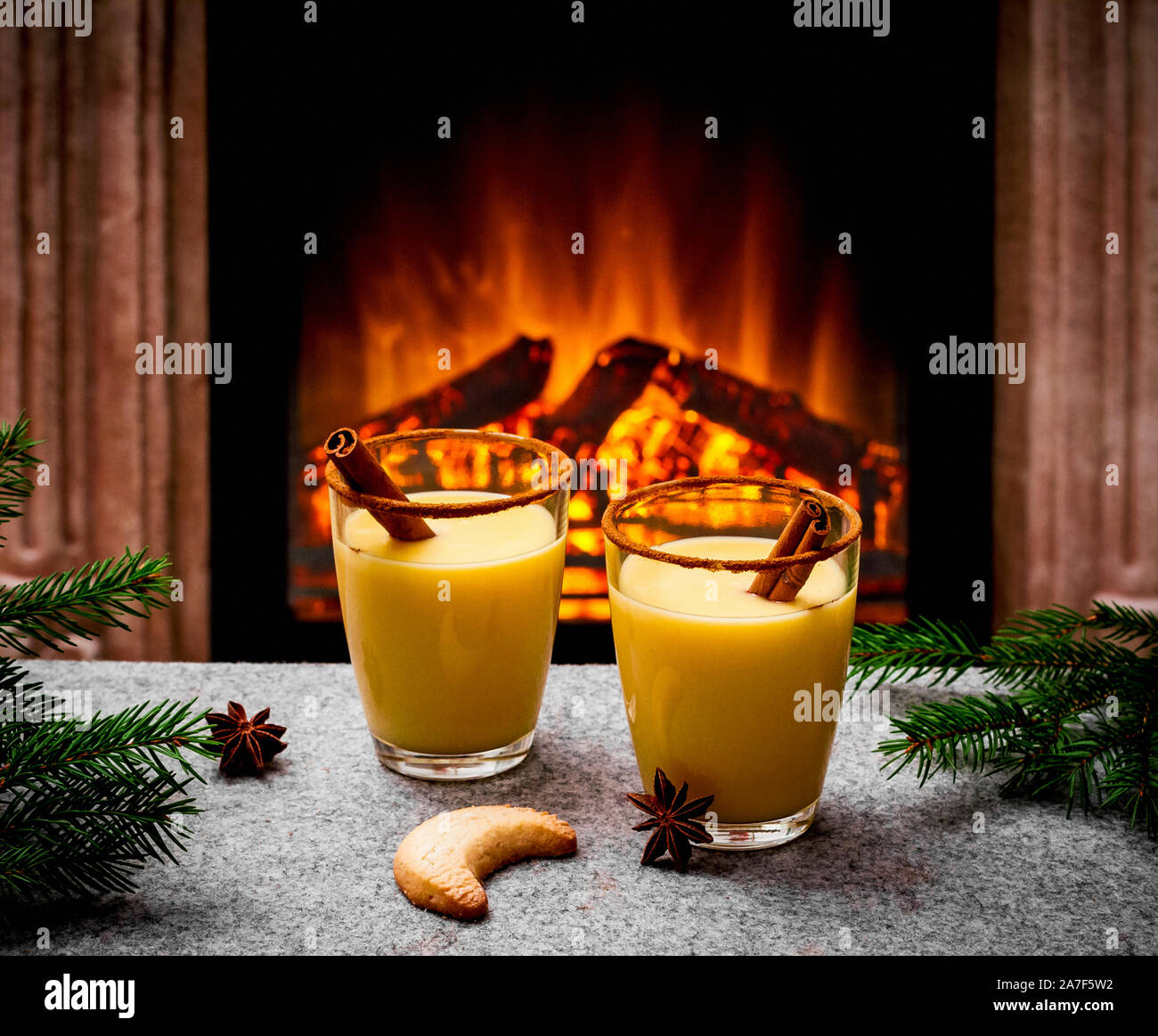 Two eggnog glasses at the fireplace, evening Stock Photo