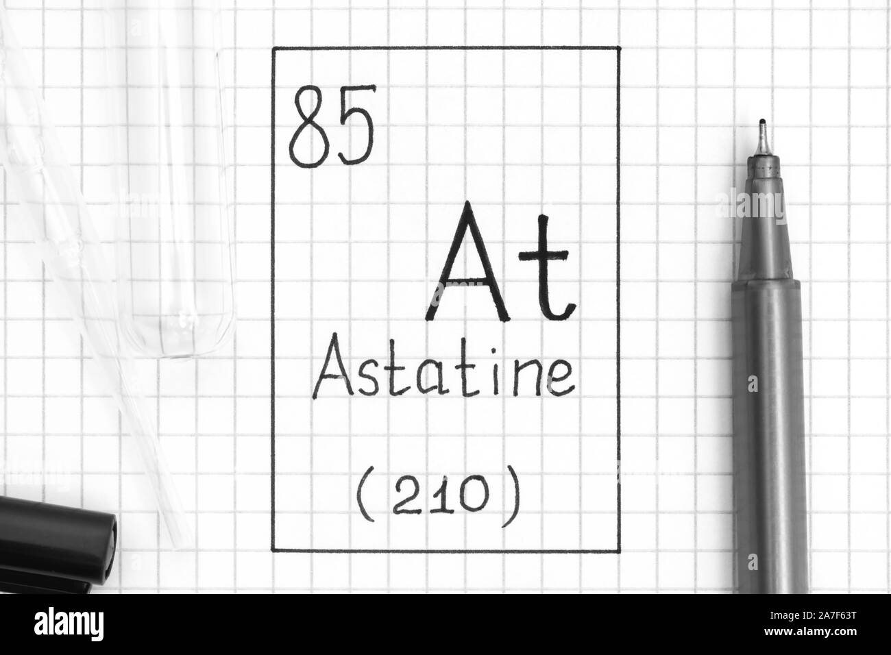 The Periodic table of elements. Handwriting chemical element Astatine At with black pen, test tube and pipette. Close-up. Stock Photo