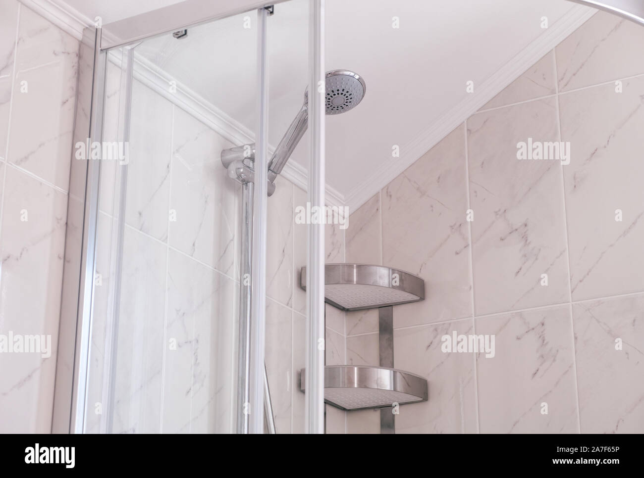 https://c8.alamy.com/comp/2A7F65P/shower-enclosure-with-shower-head-and-shelf-in-domestic-bathroom-close-up-2A7F65P.jpg