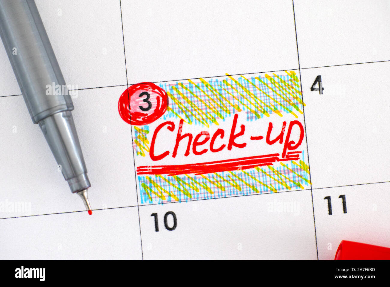 Reminder Check-up in calendar with red pen. Close-up. Stock Photo