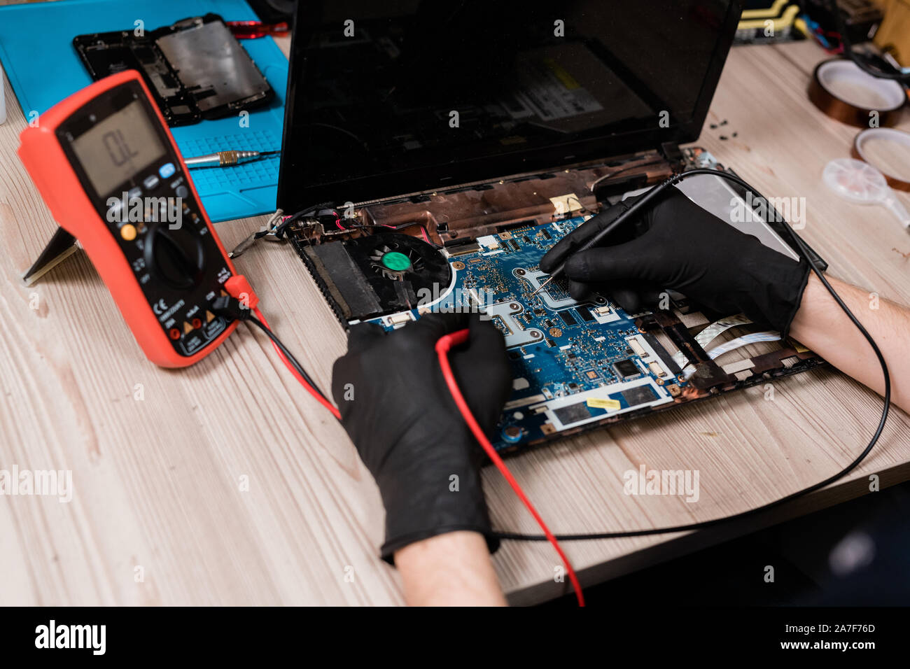 Master of repair service using solderingirons while working over