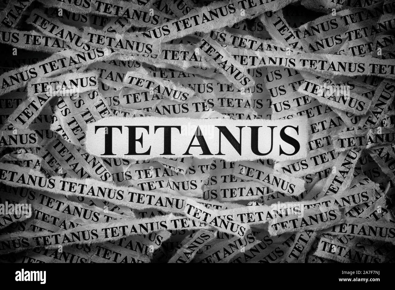 Tetanus. Torn pieces of paper with the words Tetanus. Concept image. Black and White. Close up. Stock Photo