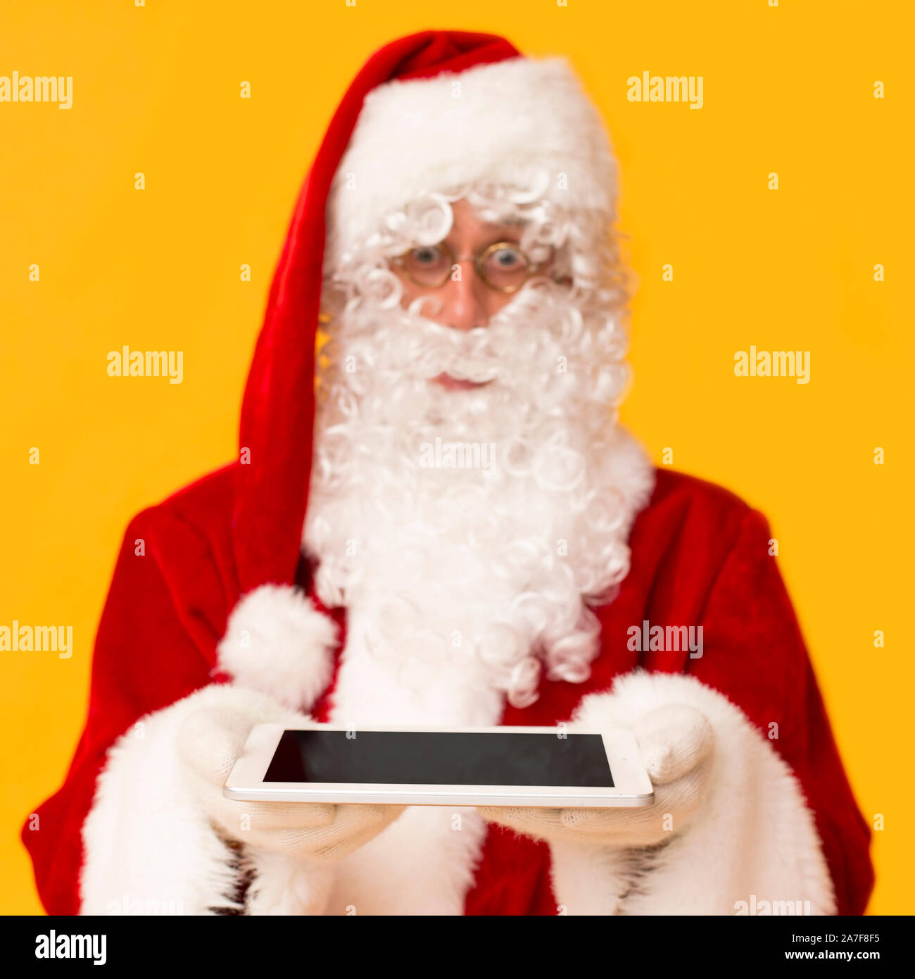 Santa Claus giving modern tablet with blank screen Stock Photo - Alamy