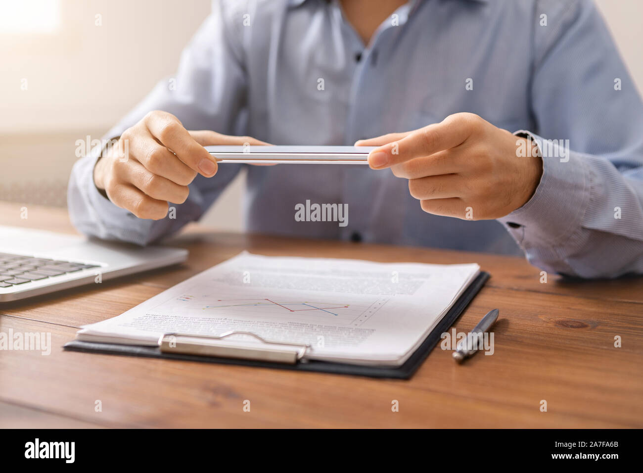 Man holding smartphone in horizontal orientation using scanner app Stock Photo