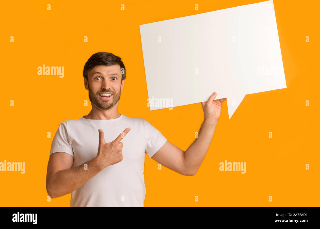Shocked Guy Showing Speech Bubble Pointing Finger Standing In Studio Stock Photo