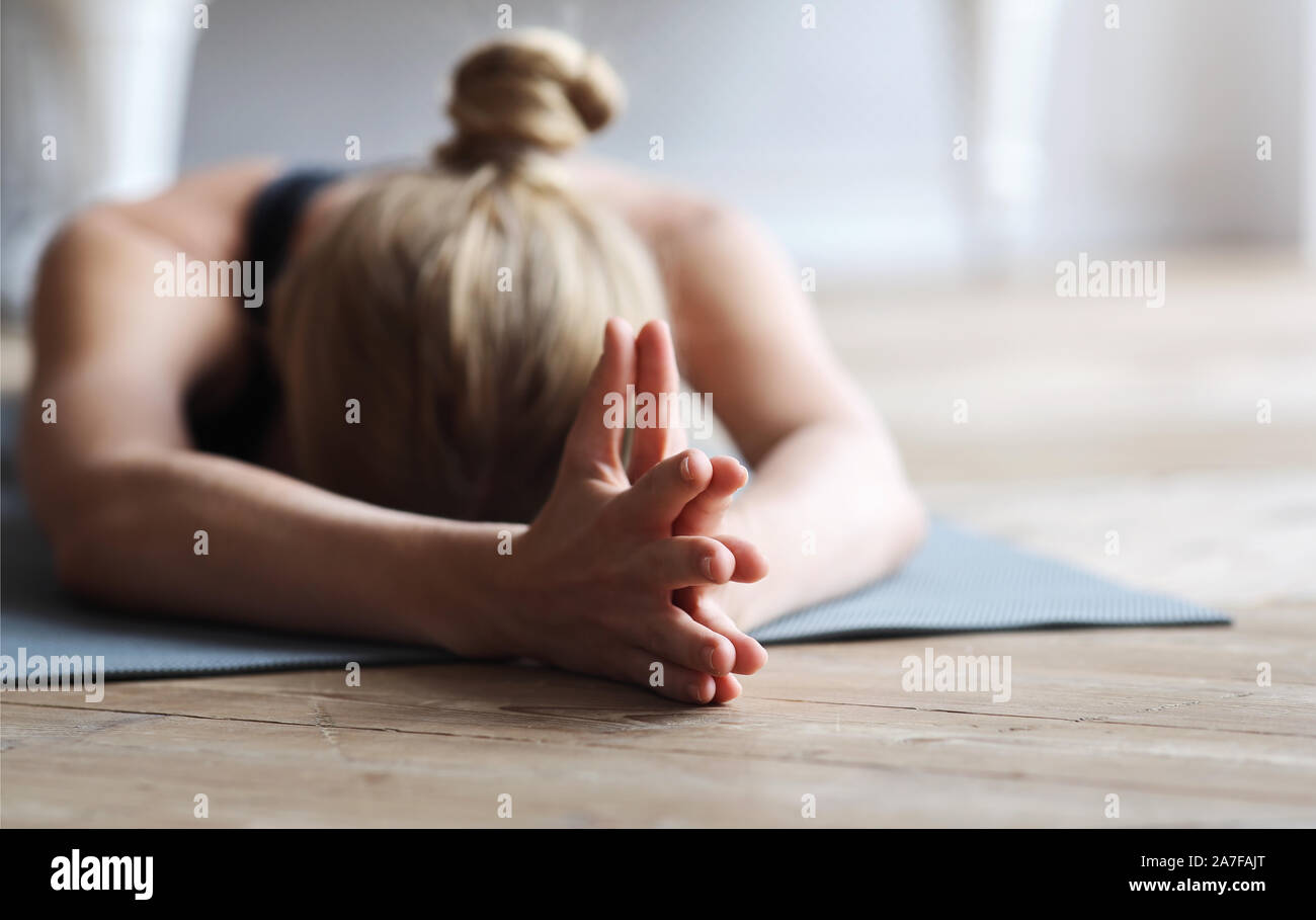 Fit girl laying face down on yoga mat, stretching Stock Photo Alamy