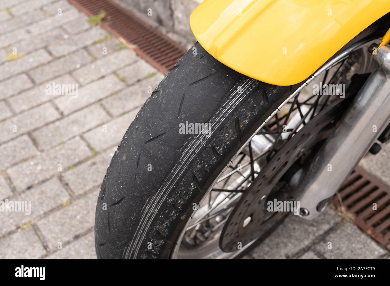 Worn tyre Motorcycle. Damaged wheel. Risky ride concept Stock Photo