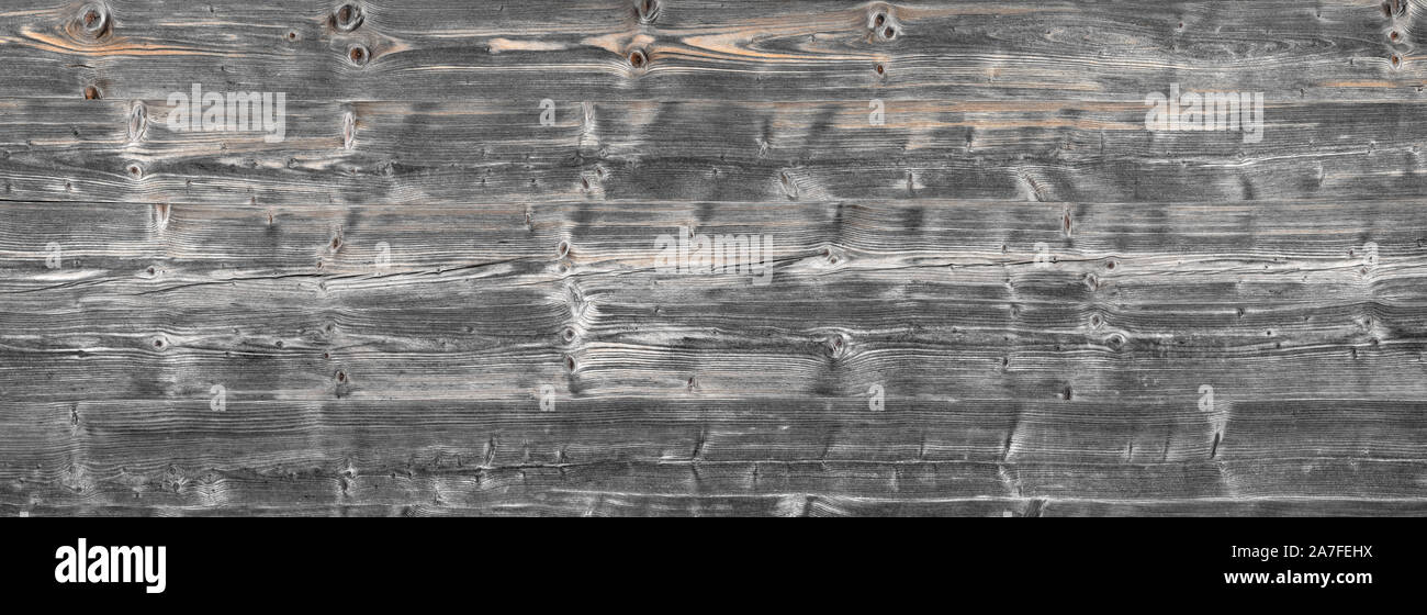 Panorama of old, stacked, gray wooden beams Stock Photo