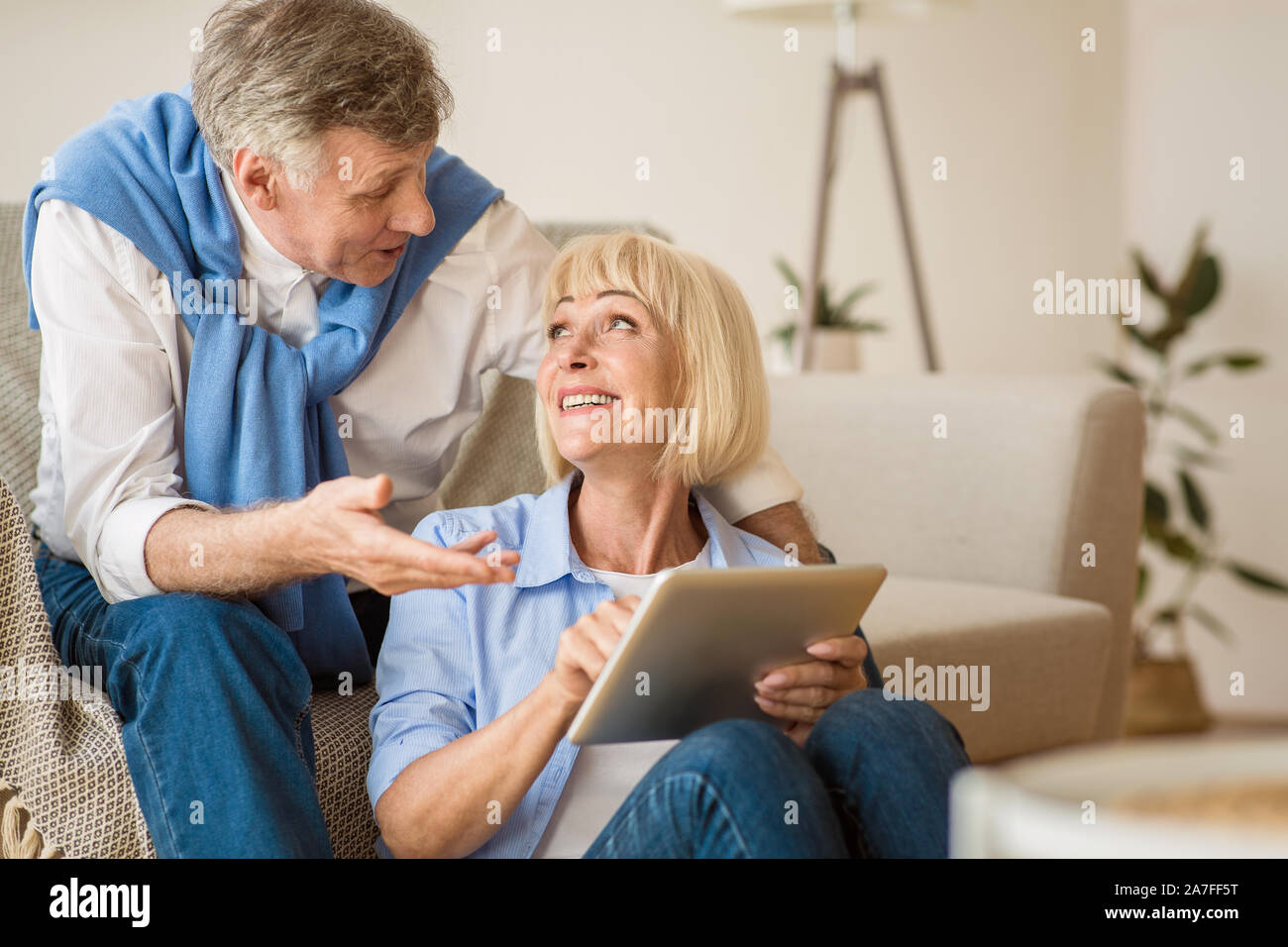 Modern senior spouses using digital tablet together Stock Photo