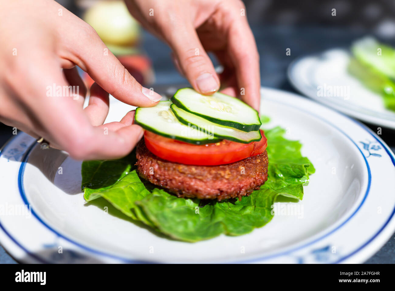 Vegan meat sausage patty on plate with romaine lettuce leaf and