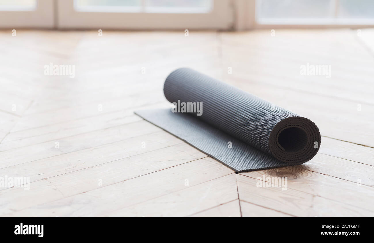 Rolled up yoga mat on wooden floor Stock Photo Alamy