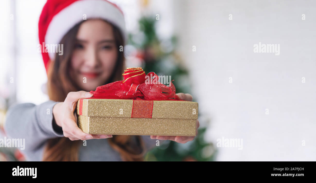 Young Asian woman holding gift box, with smiling face. Christmas present Stock Photo