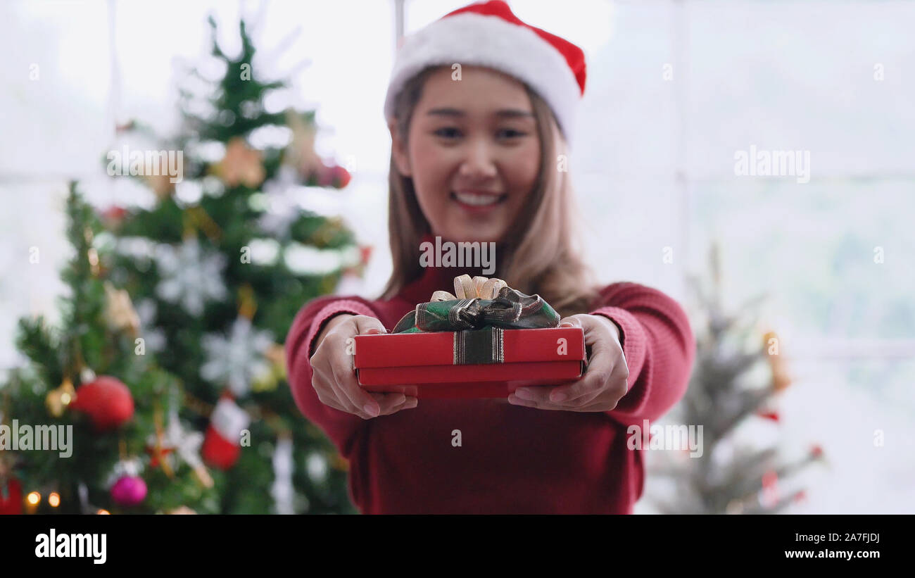 Asian girl giving Christmas present, with smiling face Stock Photo