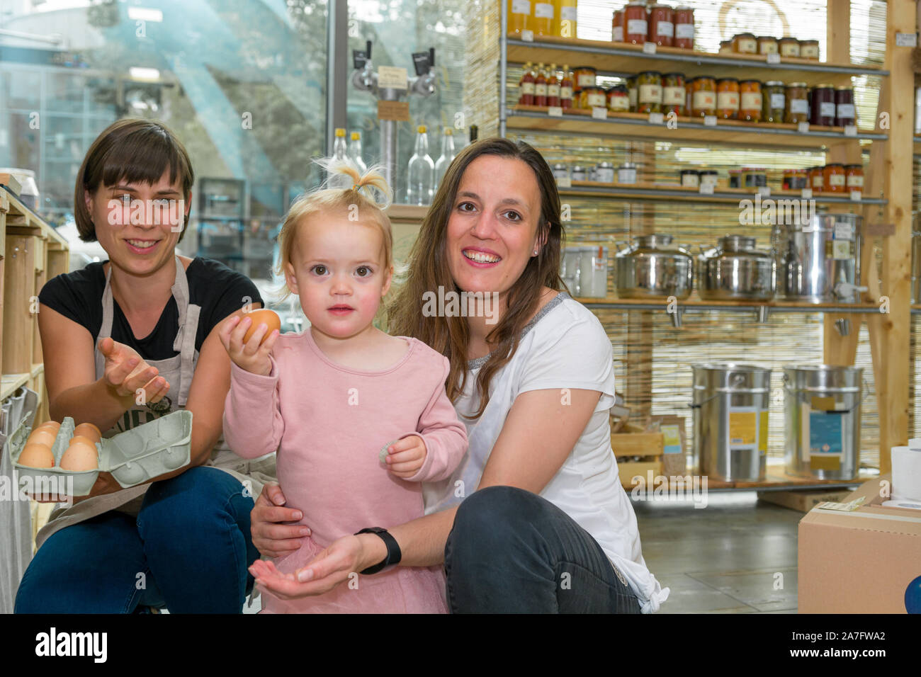 Mother and daughter picking some fresh eggs in zero waste store. Stock Photo