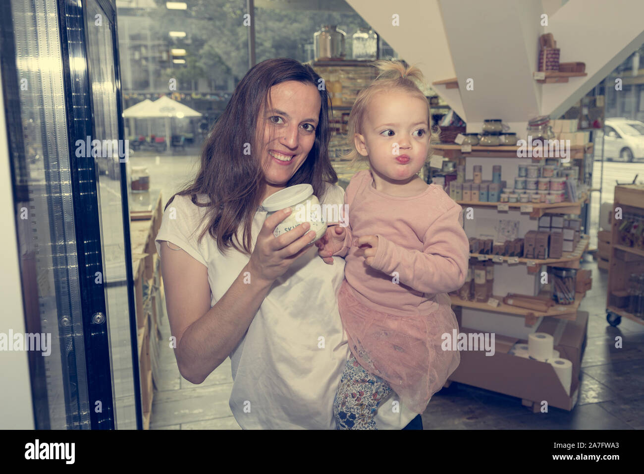 Young mother and daughter shopping in zero waste store. Stock Photo