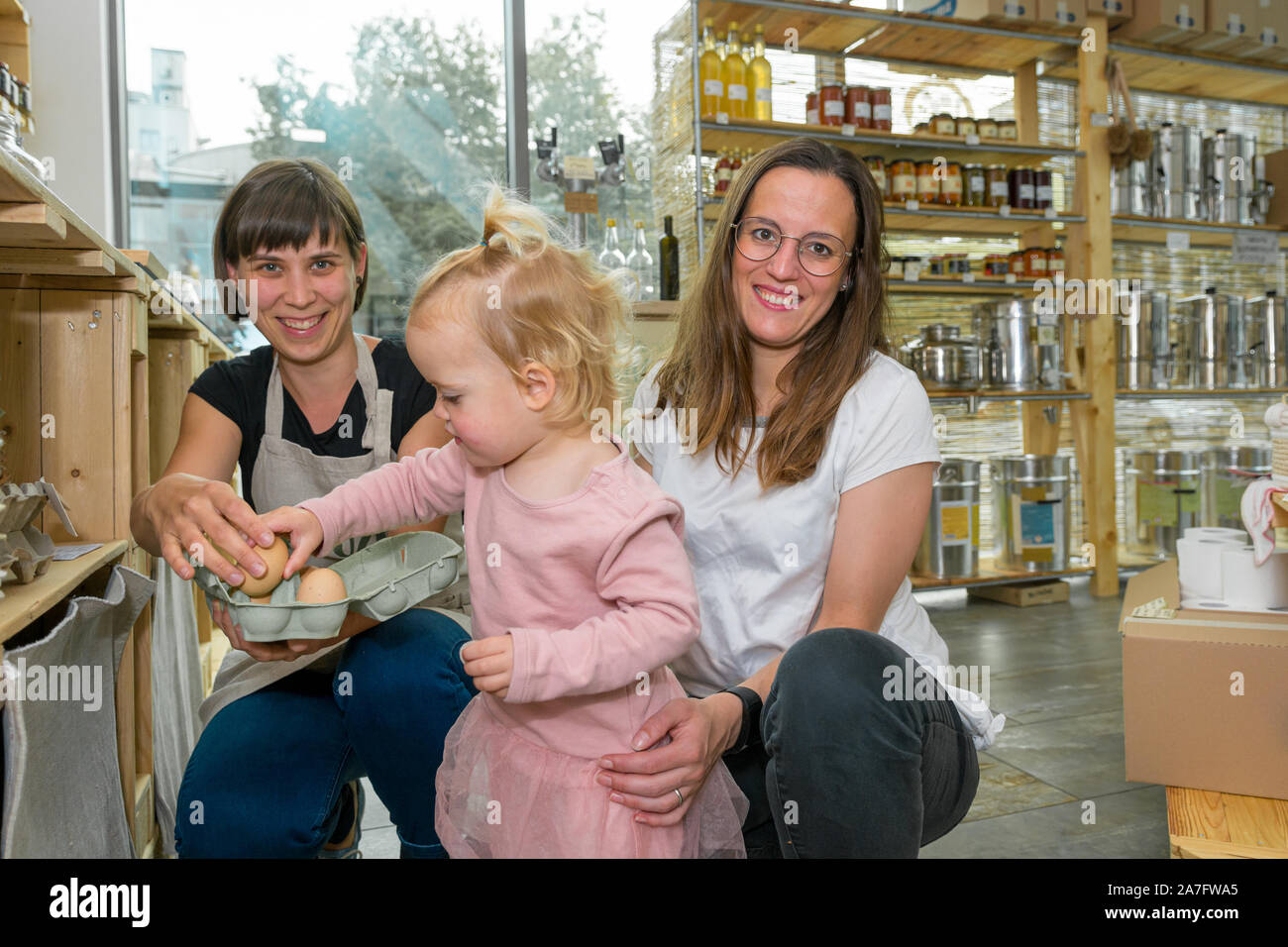 Mother and daughter picking some fresh eggs in zero waste store. Stock Photo