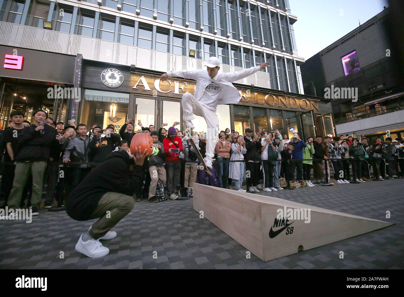Beijing, China. 02nd Nov, 2019. A Chinese skate boarder, sponsored by Nike  to promote its new line of shoes, performs stunts in front of a crowd at an  international shopping mall in