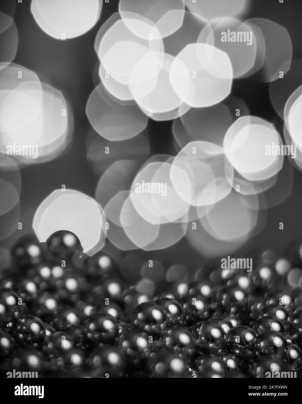 Christmas background, with blurred Christmas lights, beautiful bokeh and a chain of glossy balls in the foreground. Christmas decorations Stock Photo