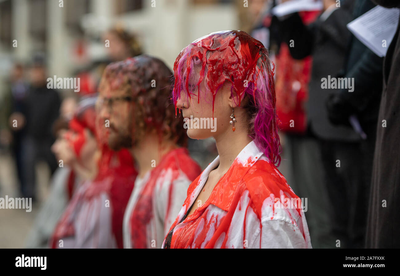 Grandparents from Extinction Rebellion pour fake blood over young people outside the Guildhall in Cambridge to highlight the inter-generational injustice of climate change. Stock Photo