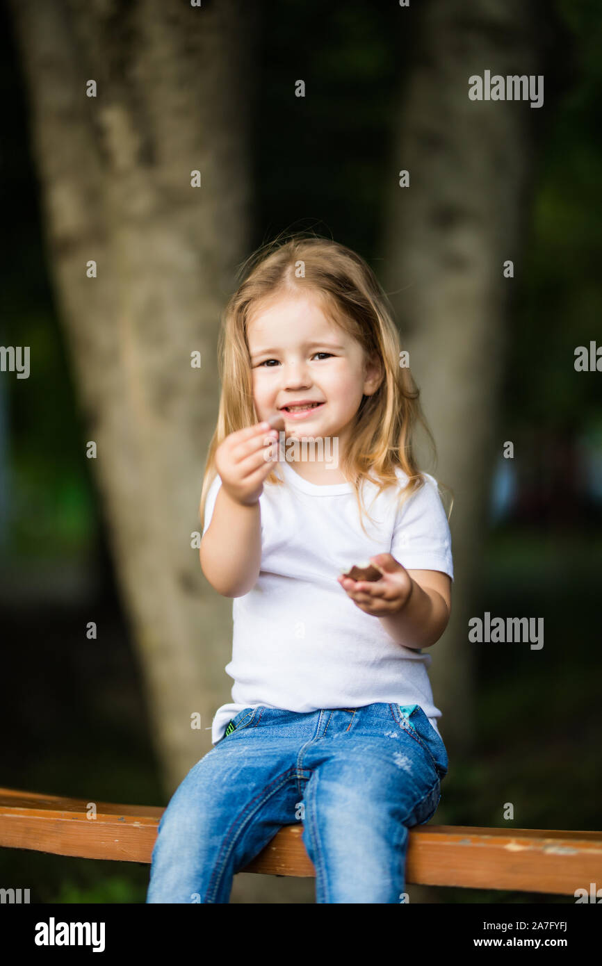 little girl sitting on the bench in park Stock Photo - Alamy