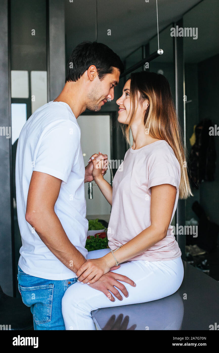 Happy couple in love communicates laughing in the morning in the kitchen Stock Photo