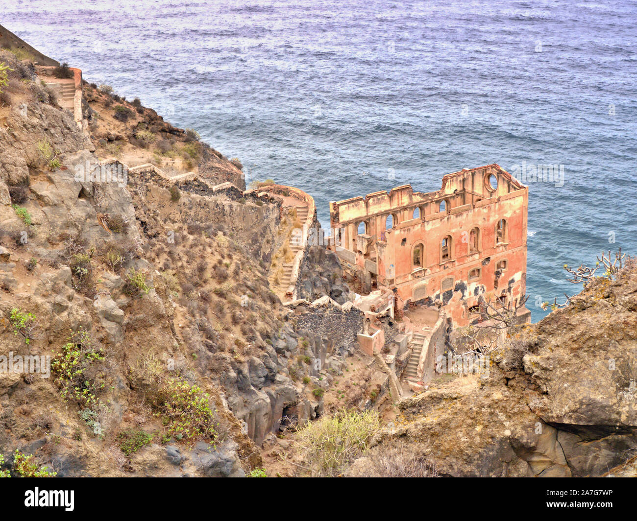 A very old ruin on the steep slope of the coast in the north of the Canary Island of Tenerife. A steep, dilapidated stairway leads down to the ruin. B Stock Photo