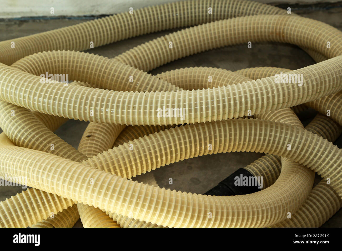Yellow plastic corrugated tubes for water supply, rolled up Stock Photo