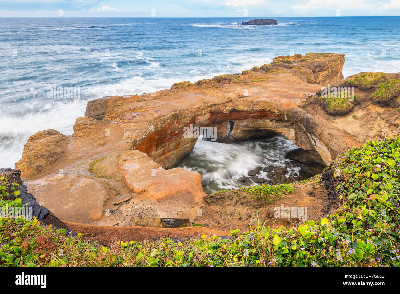 Devil's Punch Bowl in Otter Rock, Oregon, USA. It is a large bowl naturally carved in a rock headland partially open to the Pacific Ocean. Stock Photo