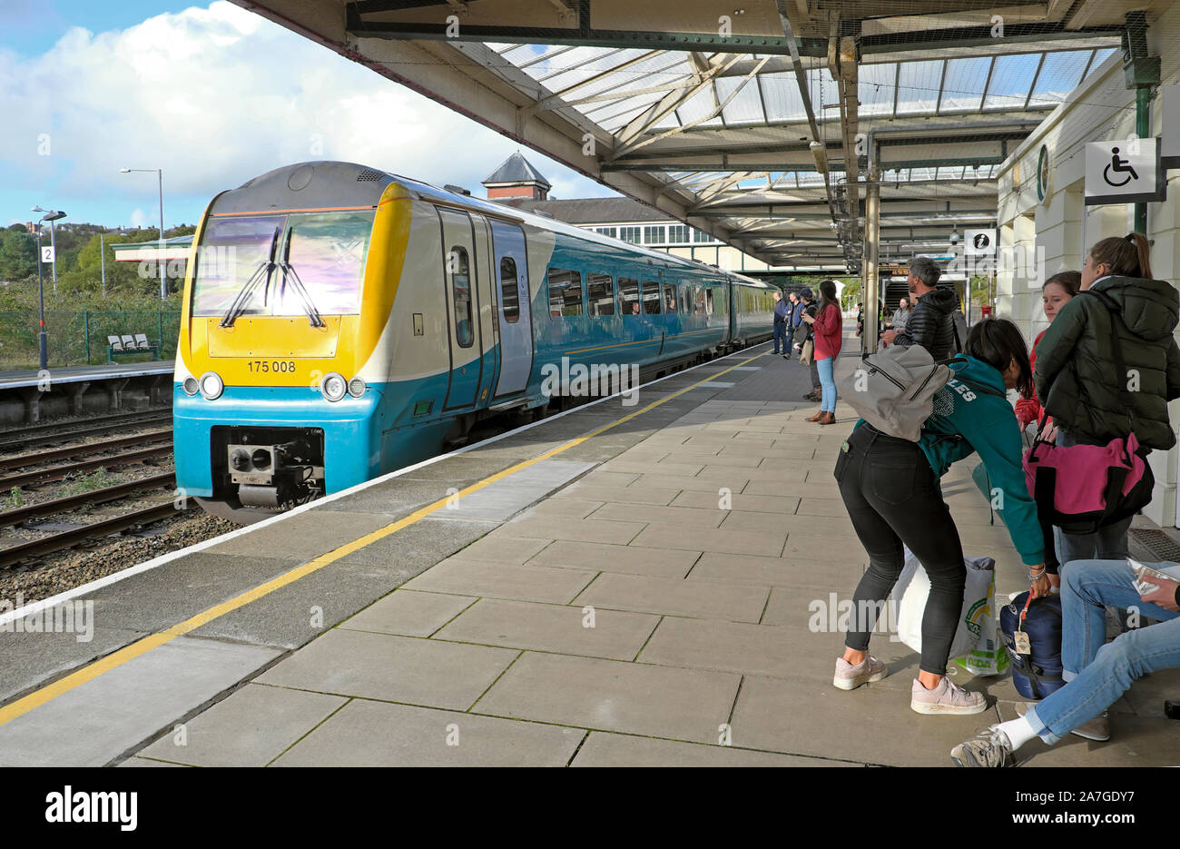 Young people with rucksacks and bags getting on a train at Bangor railway station in Gwynedd North Wales UK  KATHY DEWITT Stock Photo