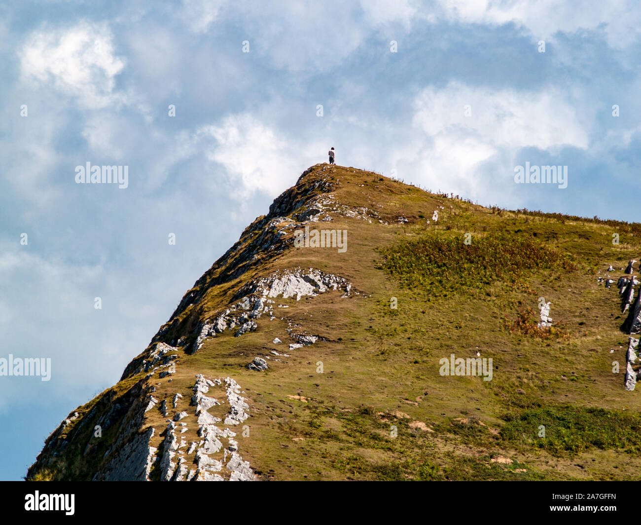 A hiker on the top of a hill near Llanmadoc, AONB. Llanmadoc, North Gower, Wales, UK. Stock Photo