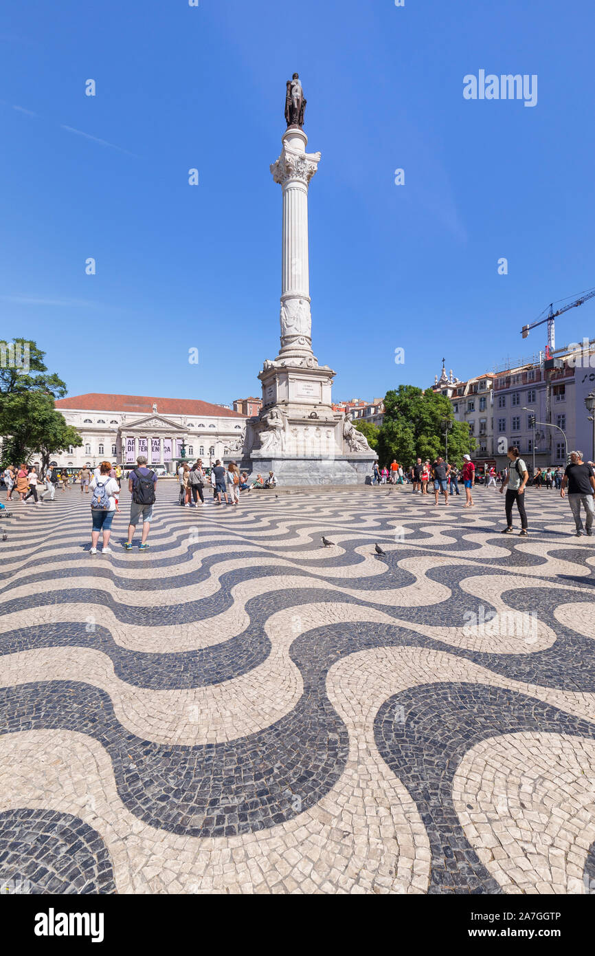 Tourists and Column and statue of Dom Pedro IV at the Rossio Square (Praca do Rossio) in the Baixa district in Lisbon, Portugal, on a sunny day. Stock Photo