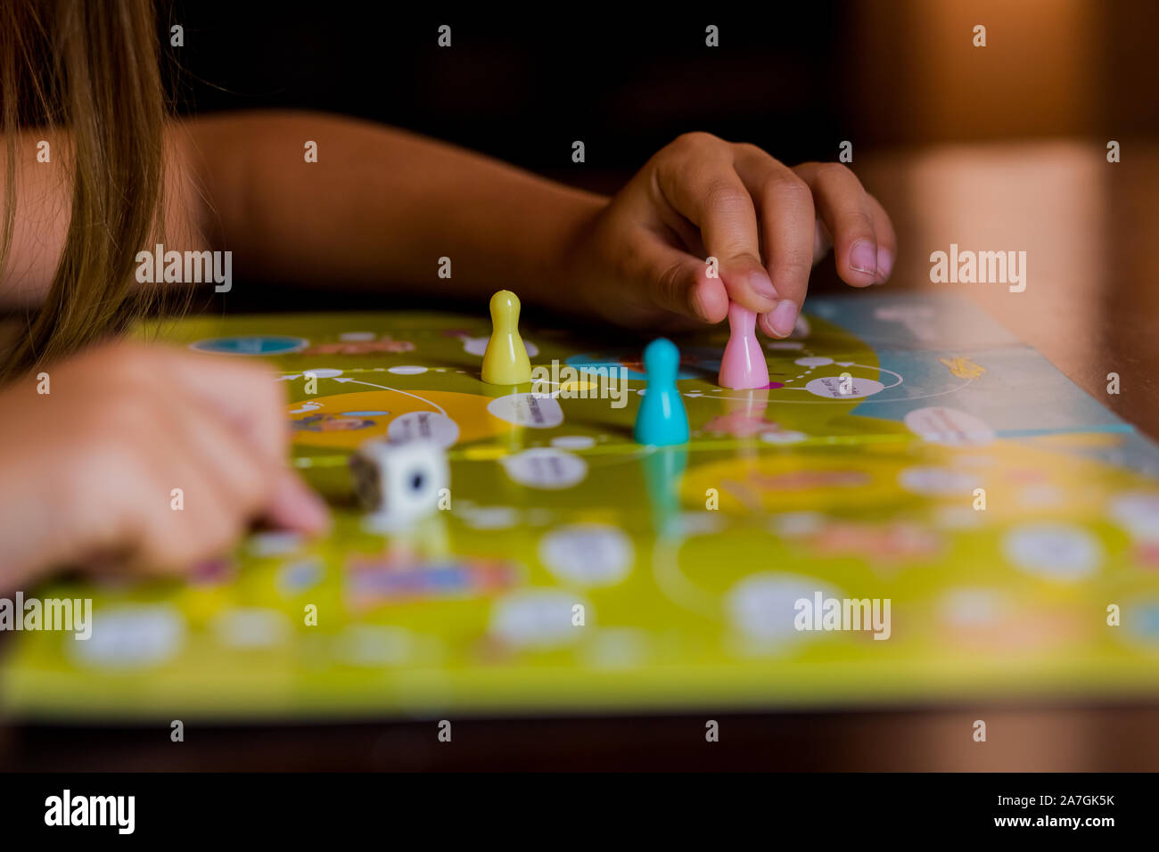 Multi-colored game chips with dice on the playing board. Board game. Stock Photo