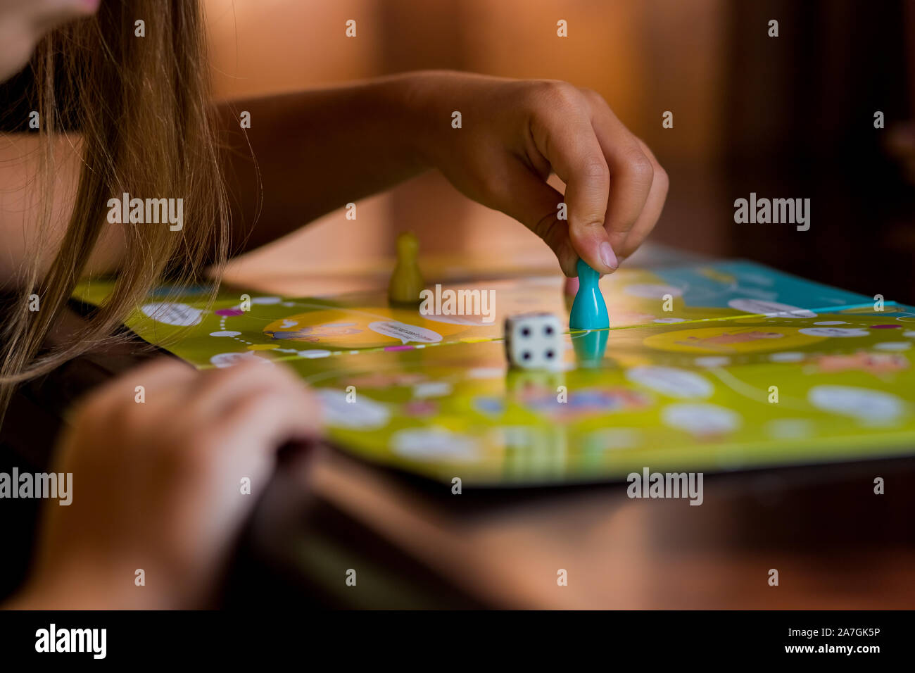 Multi-colored game chips with dice on the playing board. Board game. Stock Photo