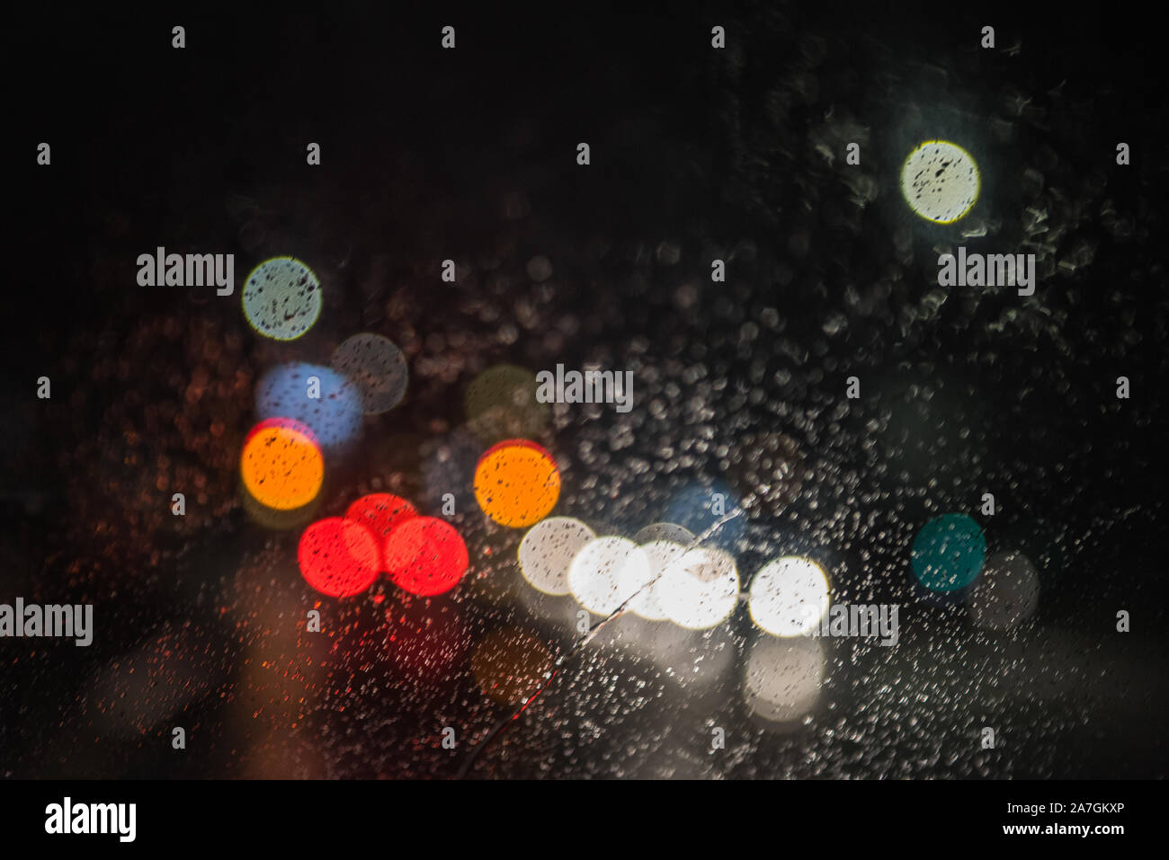 out of focus abstract car headlights in the rain with space for text on a dark background Stock Photo
