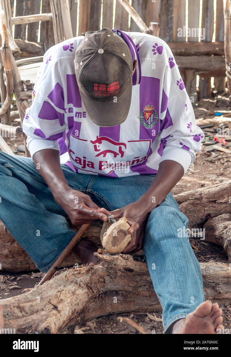 ARUSHA, TANZANIA - MAY 2014. Local Tanzanian men carving wood on the ground at Mto wa Mbu village, Arusha Region Stock Photo