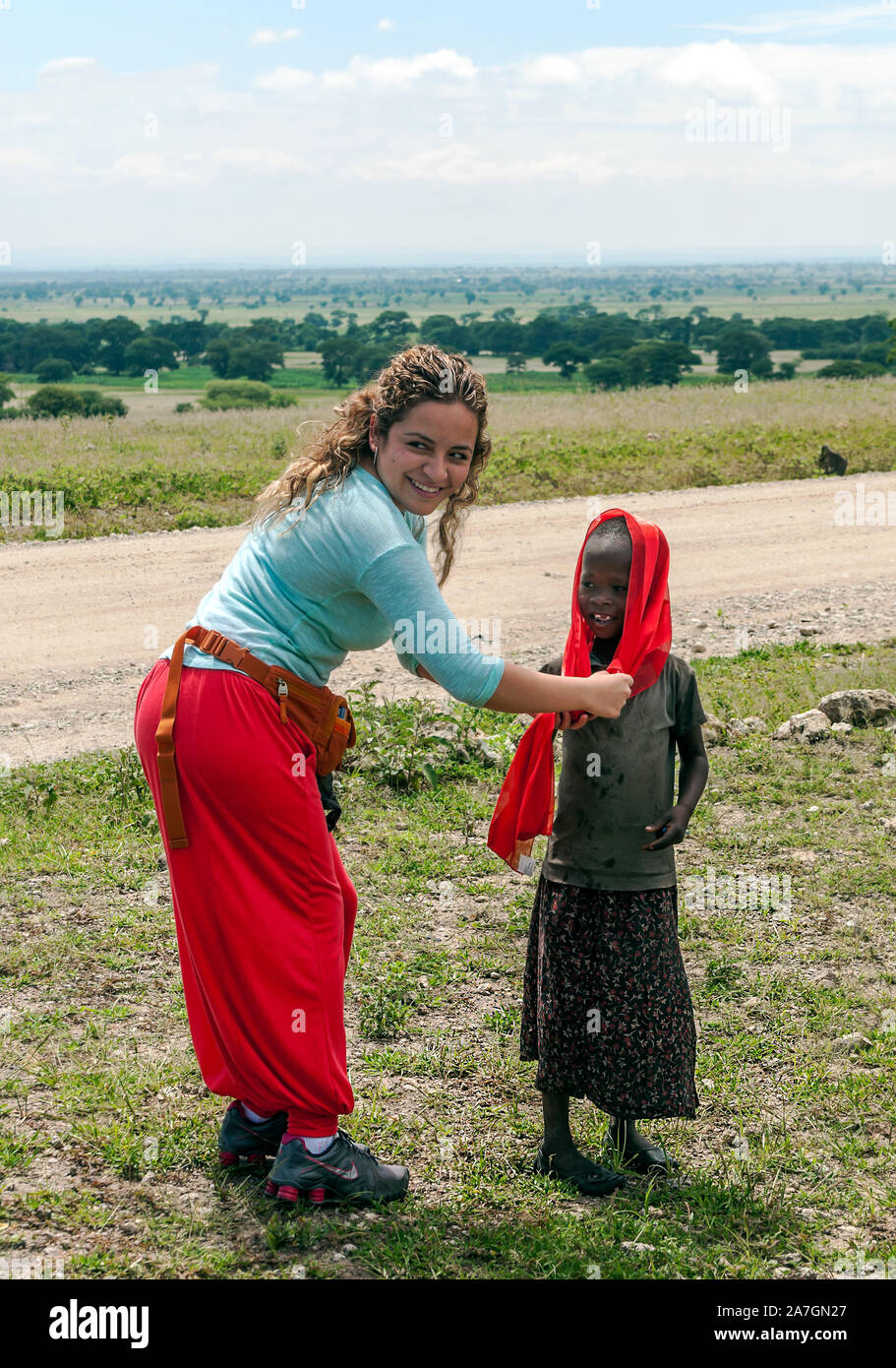 MTO WA MBU, TANZANIA - MAY 2014: Little unidentified Tanzanian children f dressed with simple and dirty clothes with european tourist in MTO WA MBU Stock Photo