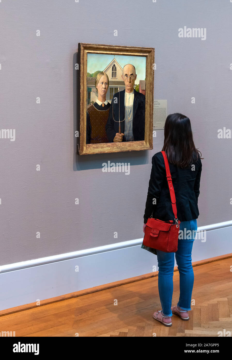 Visitor looking at the painting American Gothic by Grant Wood (1891-1942), oil on beaverboard, 1930. Art Institute of Chicago, Chicago, Illinois, USA Stock Photo