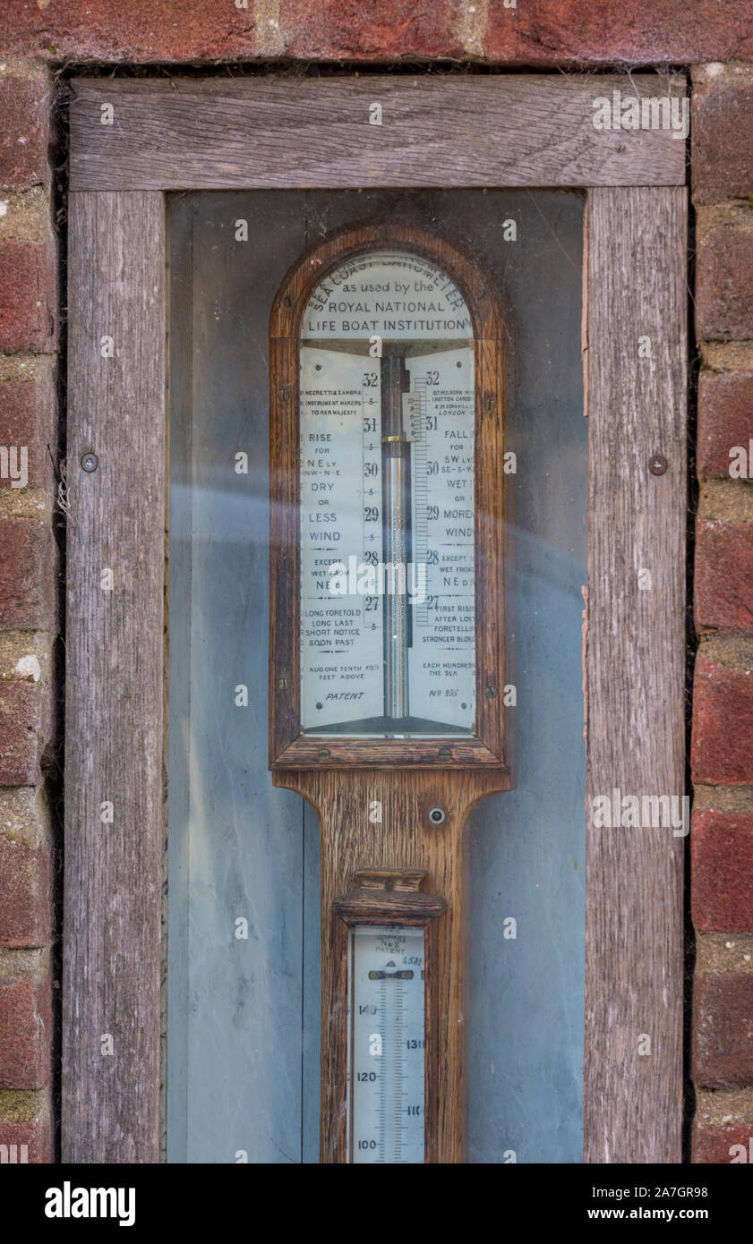 Traditional wooden lifeboat stick barometer and thermometer on the wall of a building in wells next the sea, north norfolk Stock Photo