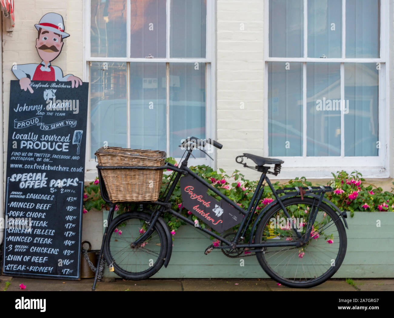 A butchers bike outside of a traditional butchers shop in Aylsham, north norfolk, uk Stock Photo