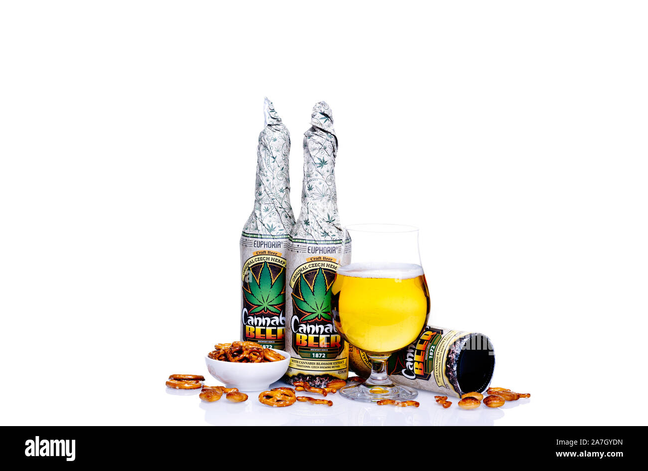 Cannabis beer Euphoria and snacks on the glass table against white background. Stock Photo