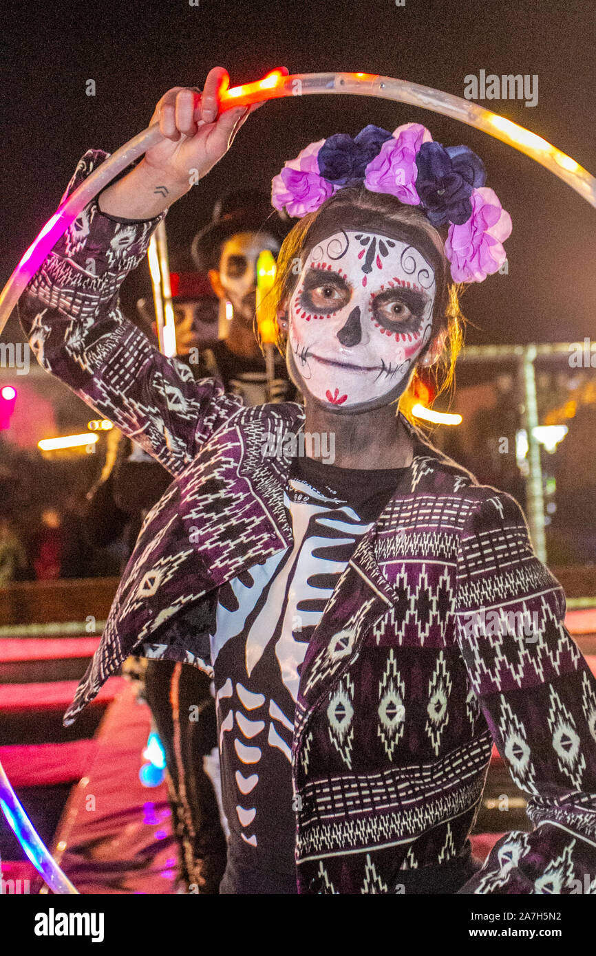 White painted ghostly faces at Southport.  ' Bring on the fire project' display at the Day Of The Dead' Festival – November is the host month to Mexico's Day of the Dead – and Southport Pleasureland staged its own twist on the spooky Mexican celebration with explosive cascade of colours and patterns created while dancing and moving with light and vibrant revelry in a feast for the senses. Stock Photo