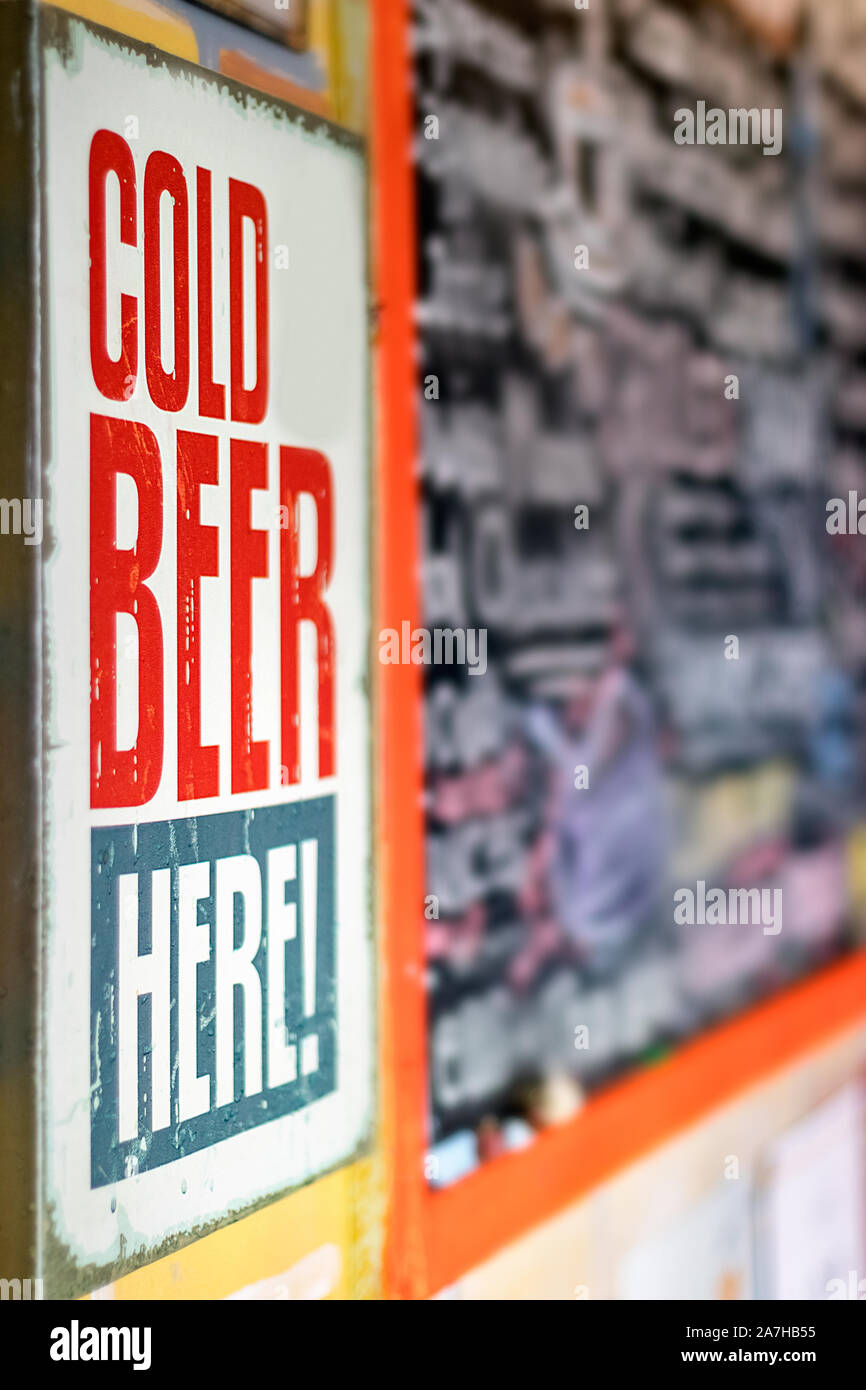 Perspective view of a vintage Cold Beer Here signboard advertisement placed on the street, outdoors. Stock Photo