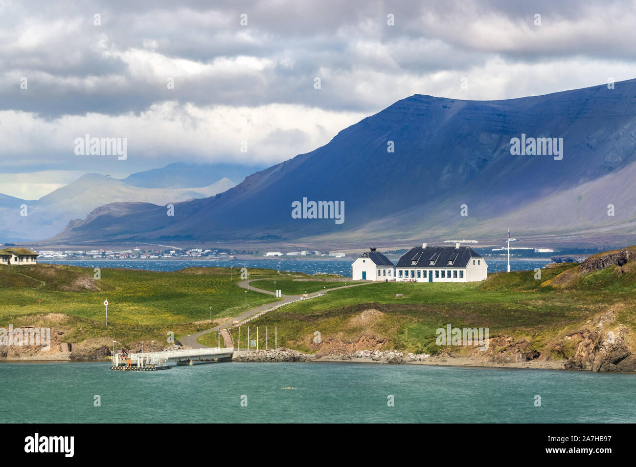 The Videy Island and an old white guest house viewed from the coastline of Reykjavik, Iceland. Stock Photo