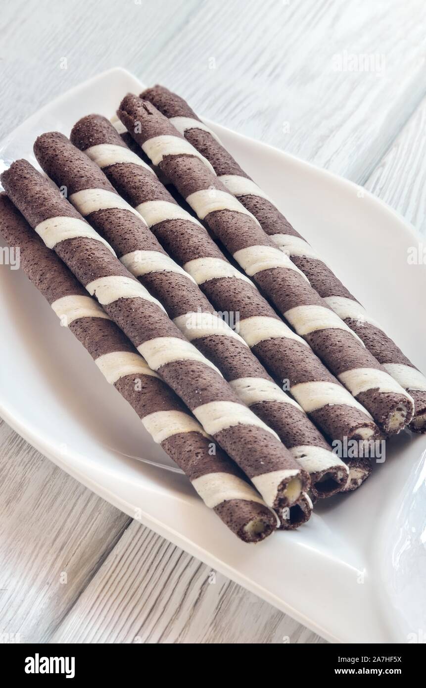 Delicious sweet snack. Tubes with chocolate and cream inside on a white  plate Stock Photo - Alamy