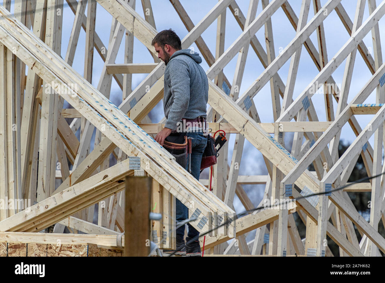 Housing construction workers installing roof trusses on a new home Stock Photo