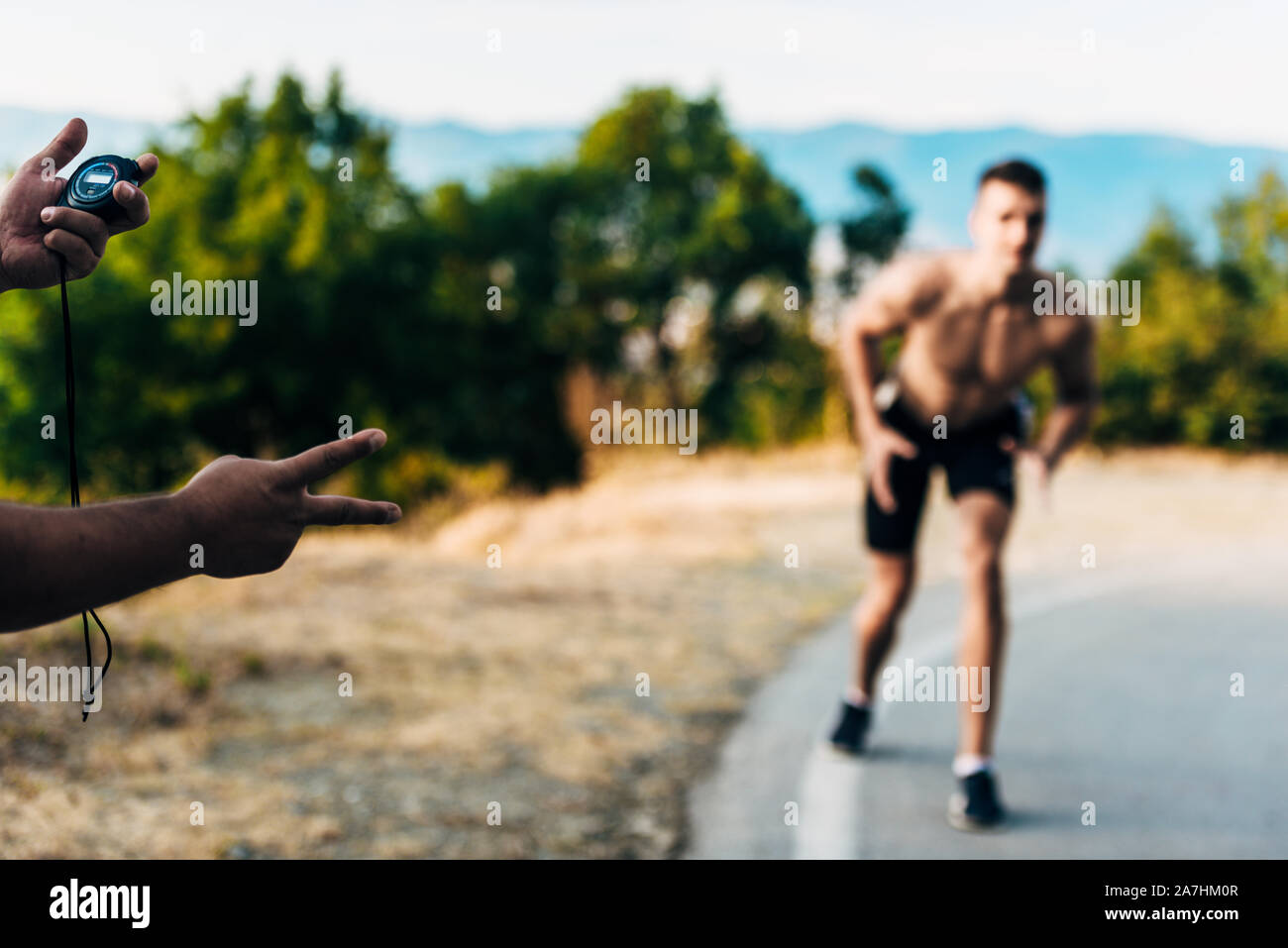 Close-up of a man holding a chronometer to measure performances of a ...