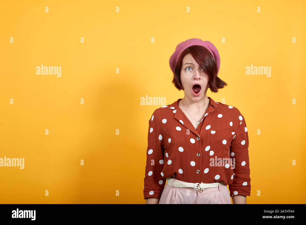 Attractive woman looking scared and surprised cheering expressing wow gesture Stock Photo
