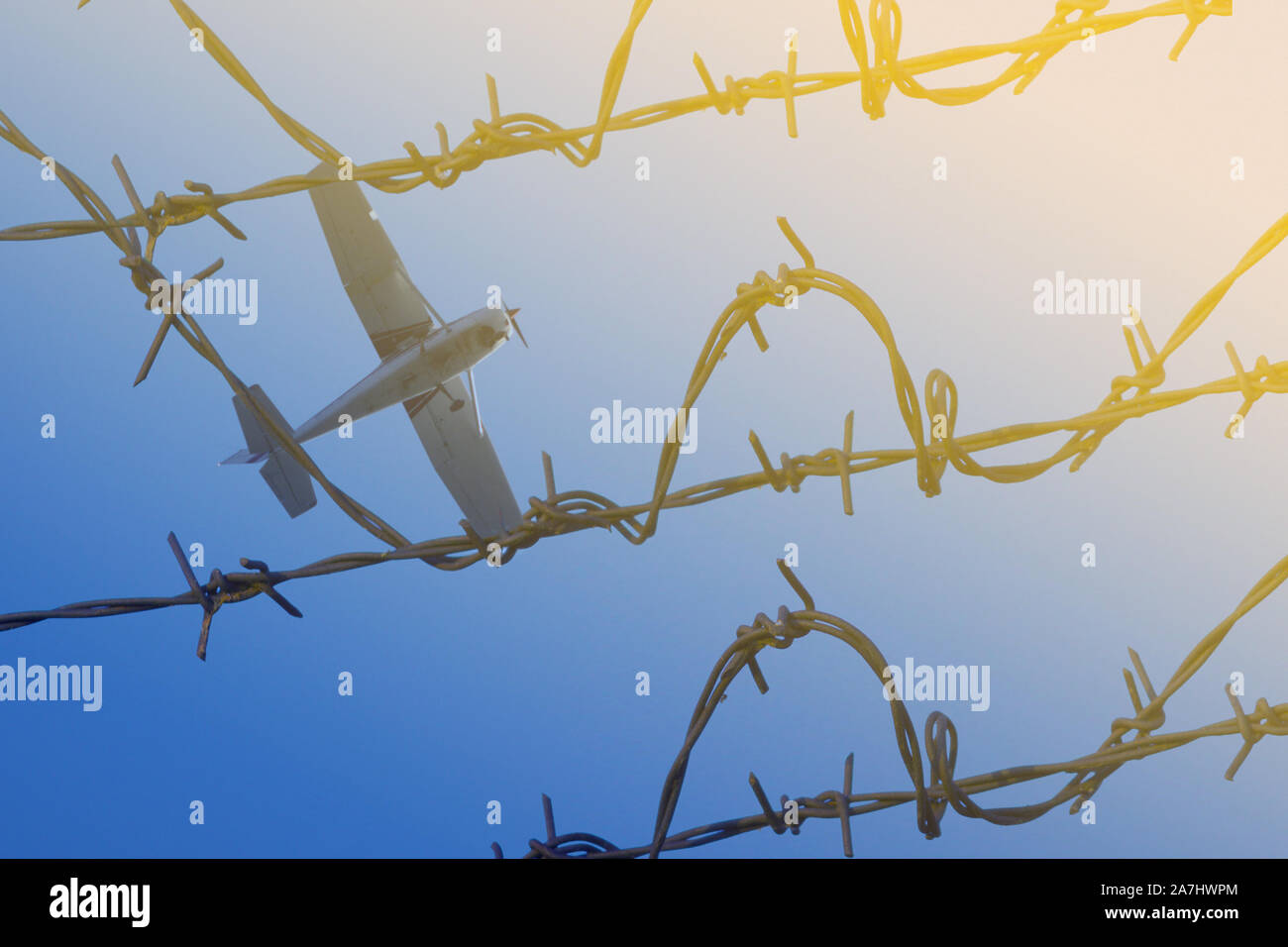 Barbed wire on fence on blue sky background Stock Photo - Alamy