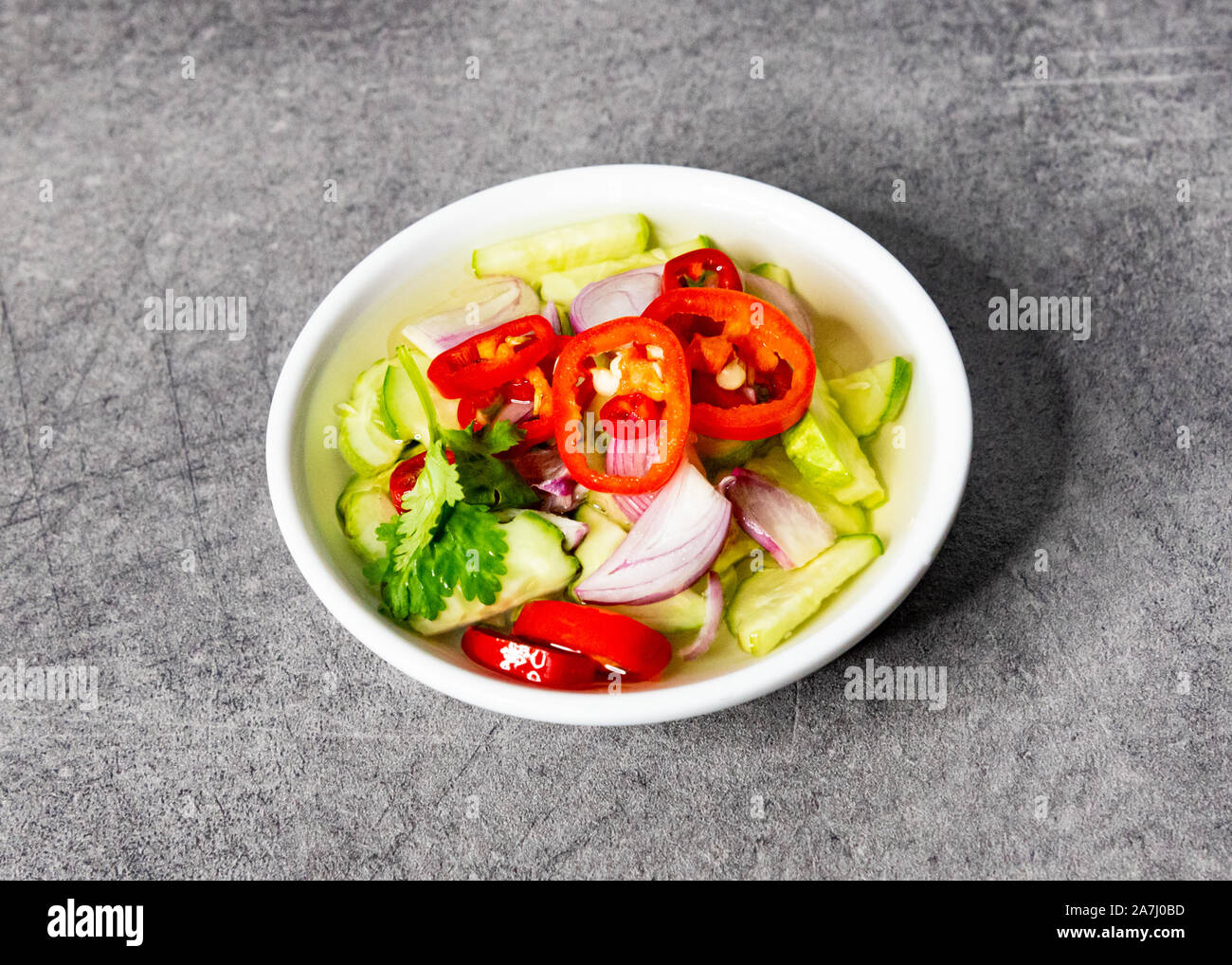 Cucumber slices chilli and onions in vinegar served with moo satay