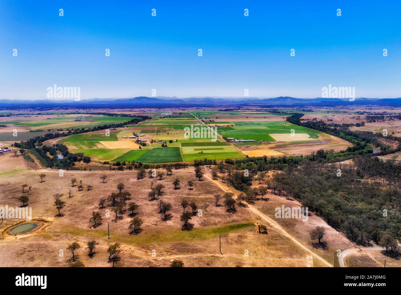 Hunter river looping around flat plains in Hunter Valley providing water and irrigation to agriculture farm. Aerial view of river bend on wide arid pl Stock Photo